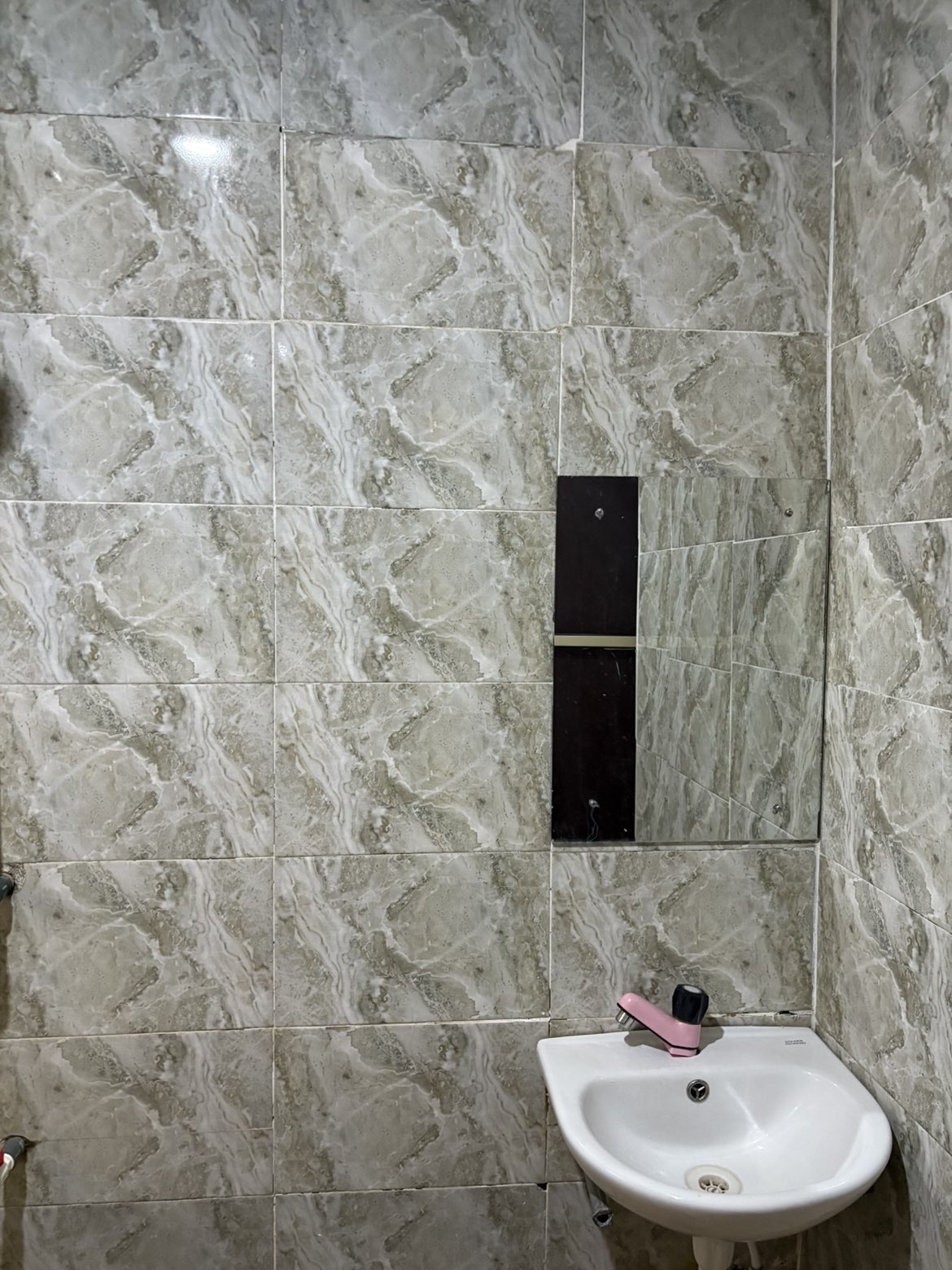 Stone-tiled bathroom with basin and mirror
